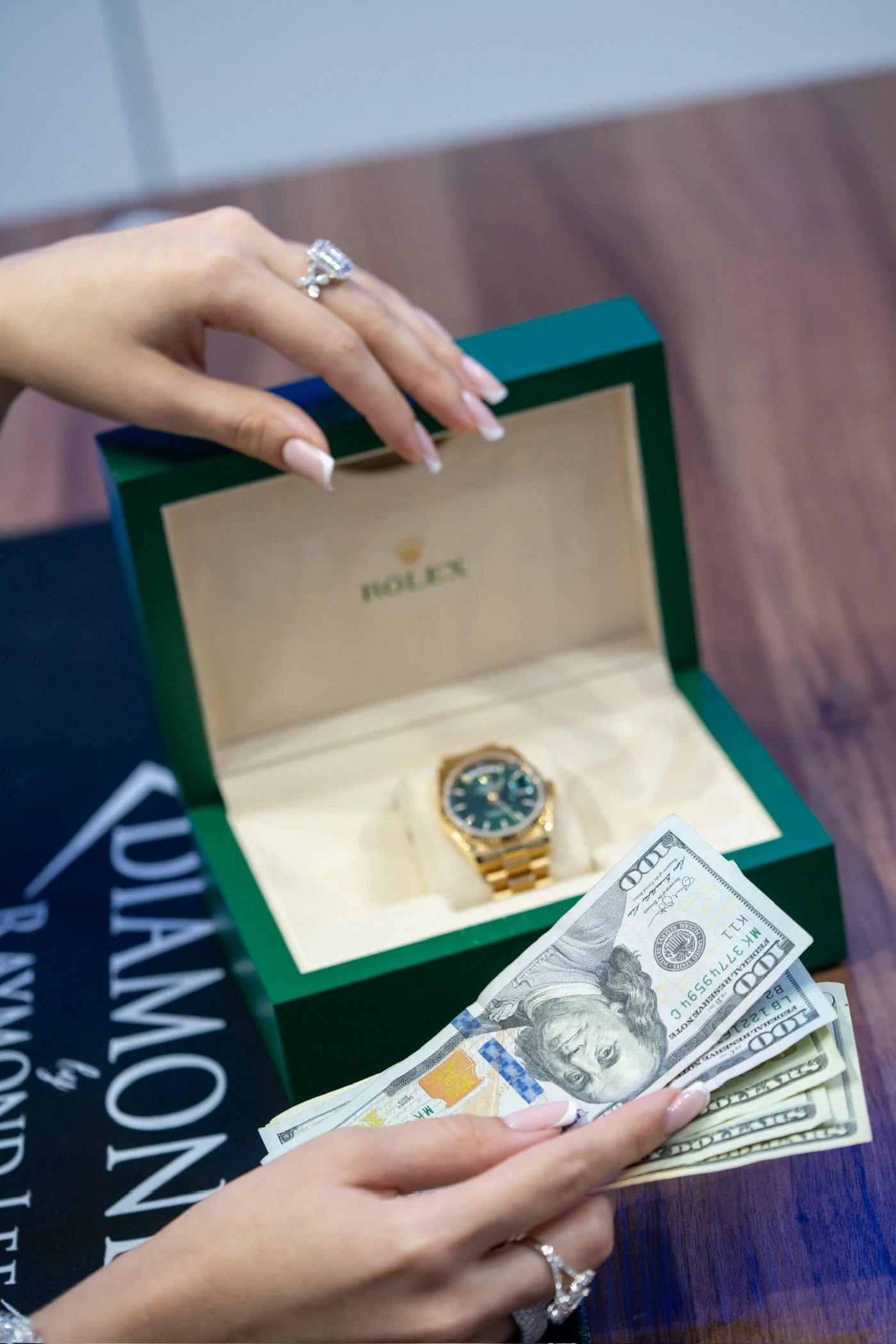 Gold tone wristwatch in an open green presentation box