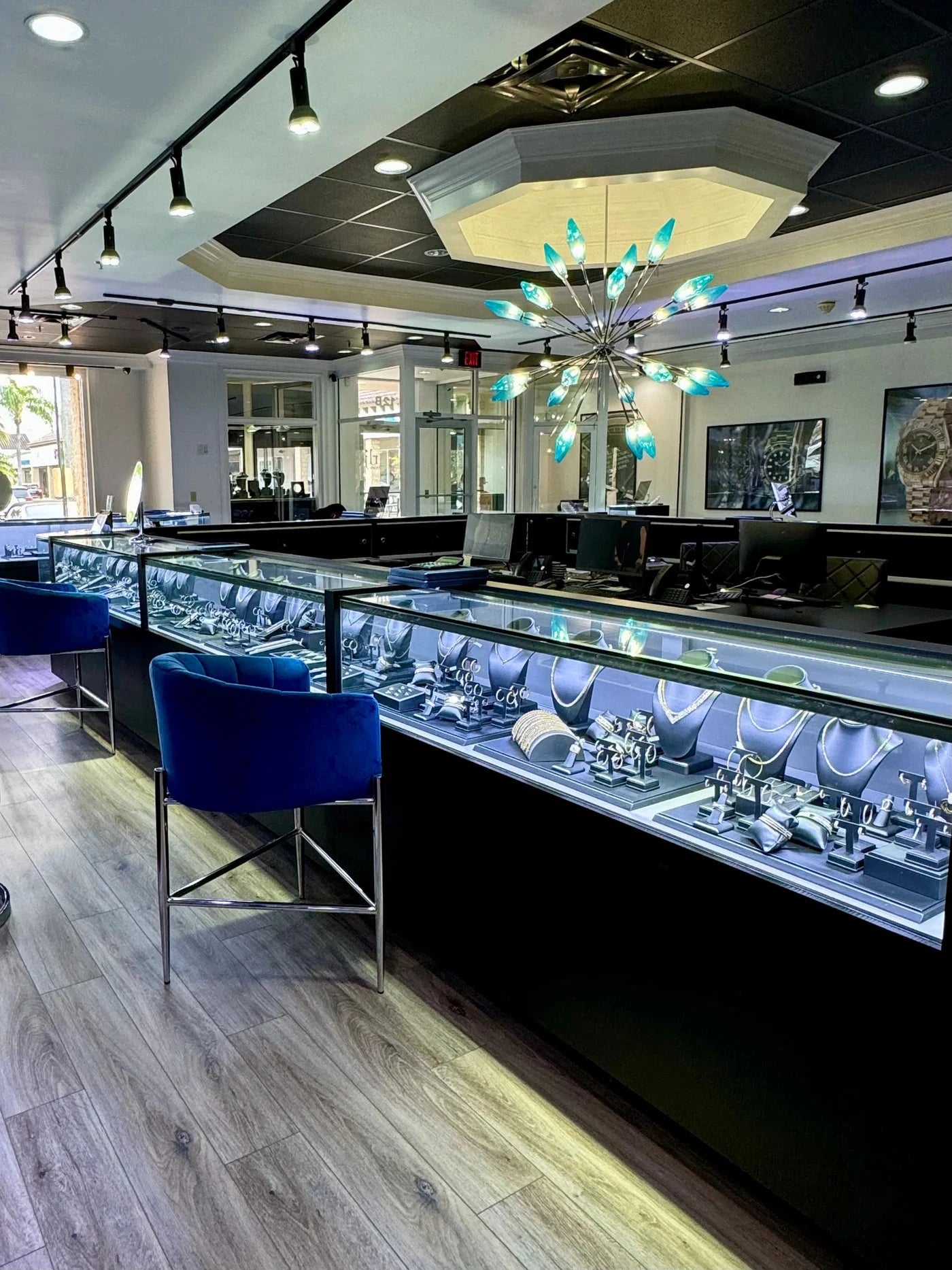 Jewelry display cases and blue chairs inside Raymond Lee Jewelers