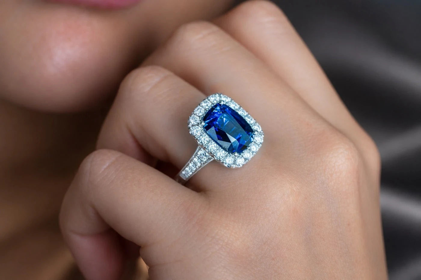 Rectangular blue center stone ring worn on a hand