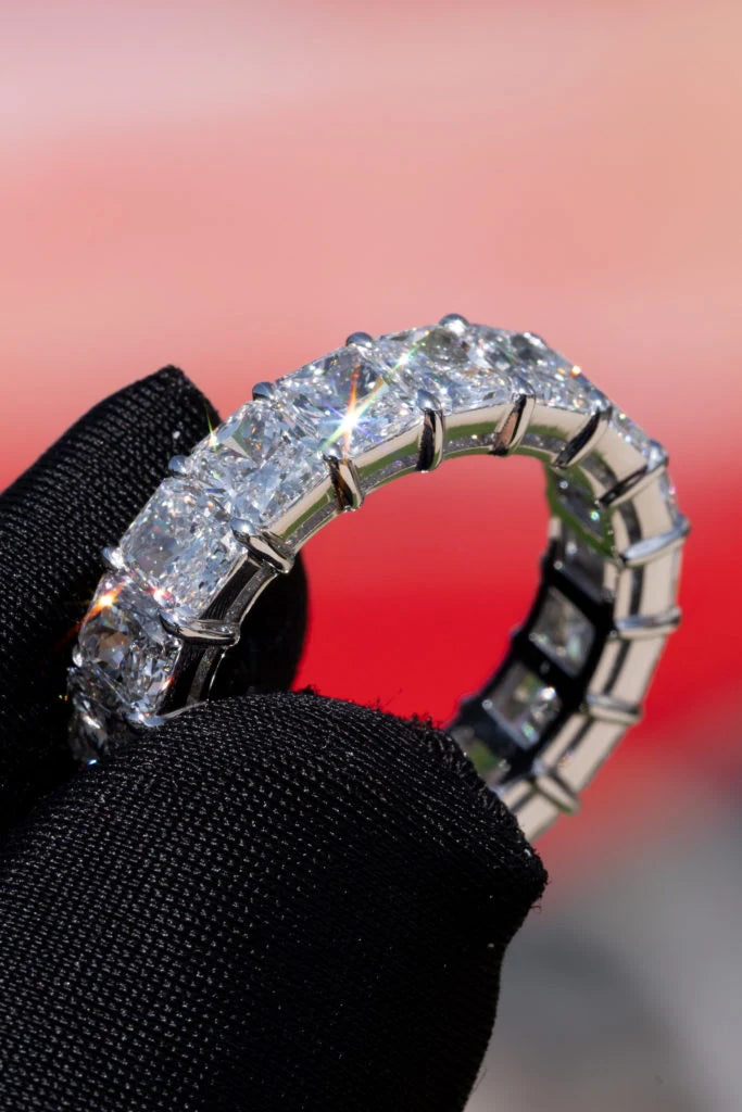 Eternity band with square stones held in a black glove