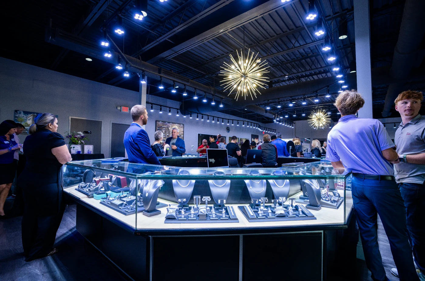 Guests browsing jewelry displays inside Diamonds by Raymond Lee
