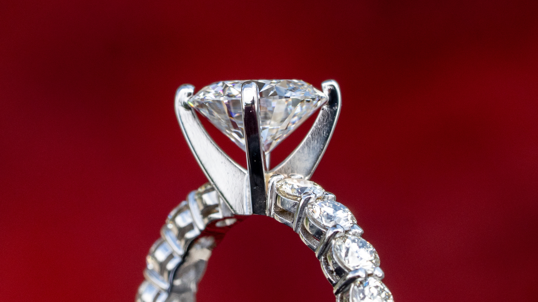 Side view of a center stone ring with a raised setting and stones around the band.