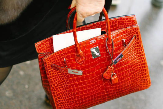 A red Hermès Birkin with a textured surface and silver tone hardware.