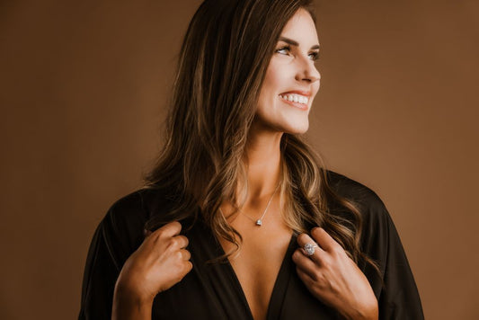 A model wearing a cluster ring and a small pendant necklace.