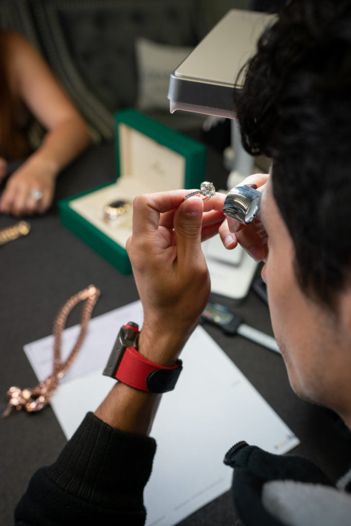A ring being examined with a jeweler’s loupe.