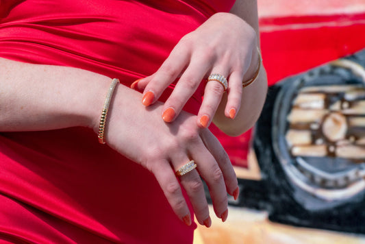 Stone set bands worn with yellow metal bracelets.