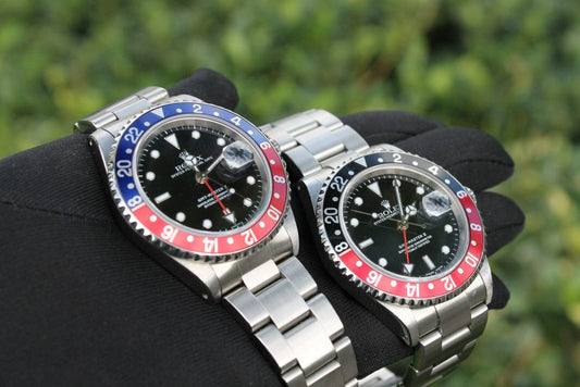 Two Rolex GMT watches with red and blue, and red and black bezels.