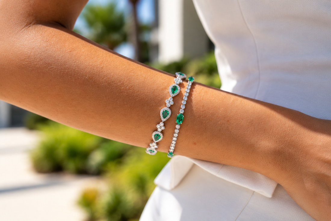 Green and clear stone bracelets worn together, rather than pearl jewelry.
