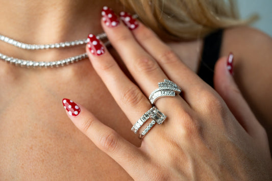 Two line necklaces worn with a rectangular center ring and stone set bands.