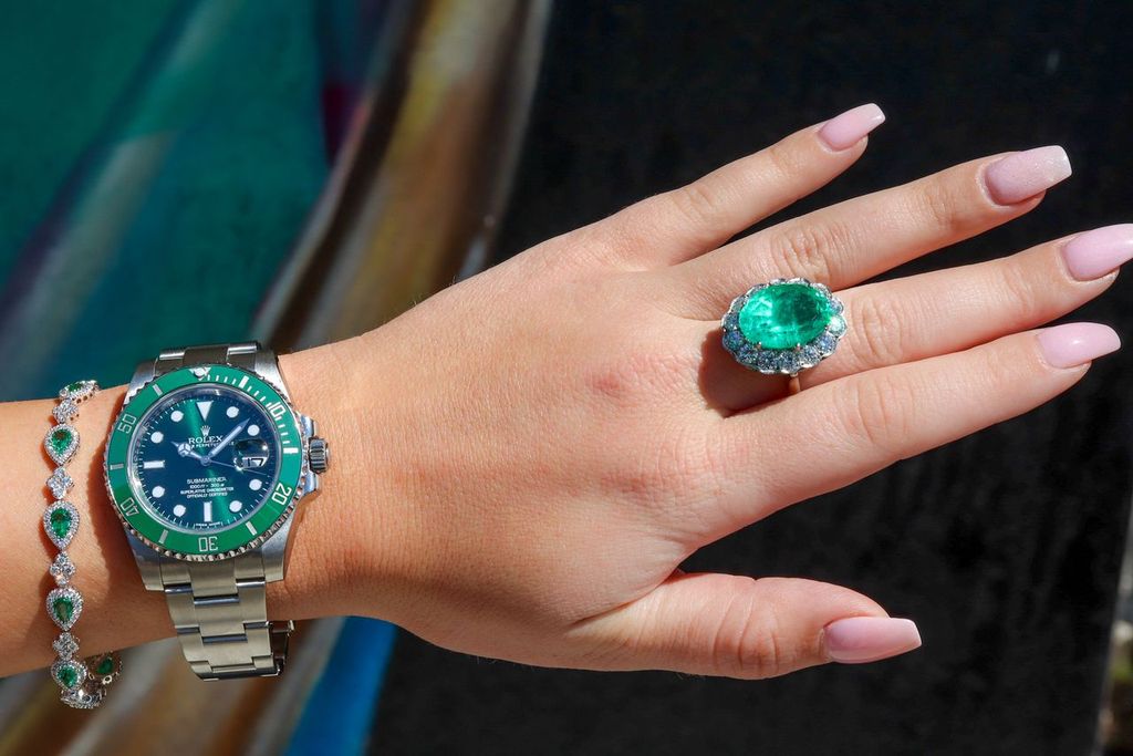 A green bezel Rolex Submariner worn with green stone jewelry, rather than a Daytona.