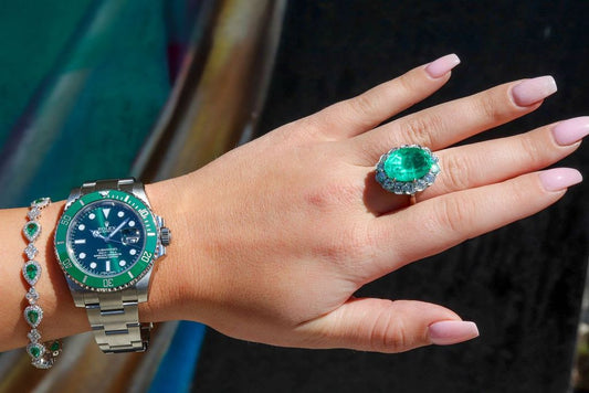 A green bezel Rolex Submariner worn with green stone jewelry, rather than a Daytona.