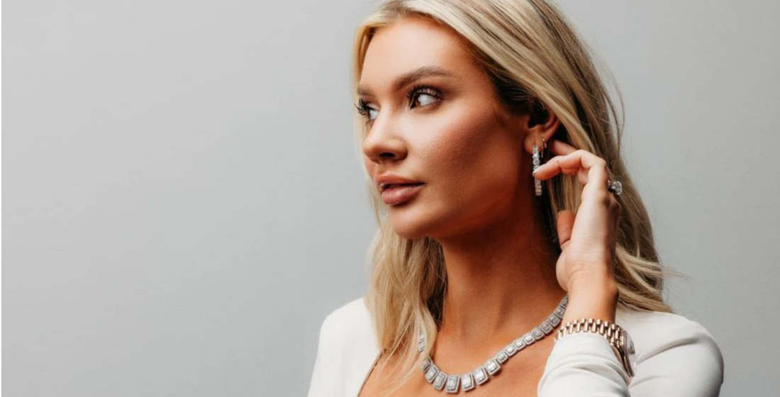 A model wearing a geometric necklace, earrings, a ring and a watch.