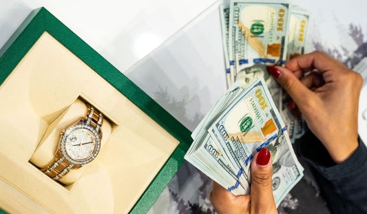 Cash counted beside a decorated watch in a presentation box; illustrative photograph, not a quoted offer.
