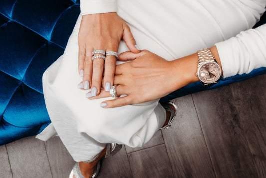 Several stone set bands and a center stone ring worn across both hands.