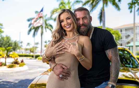 Two models wearing jewelry beside a gold colored car.
