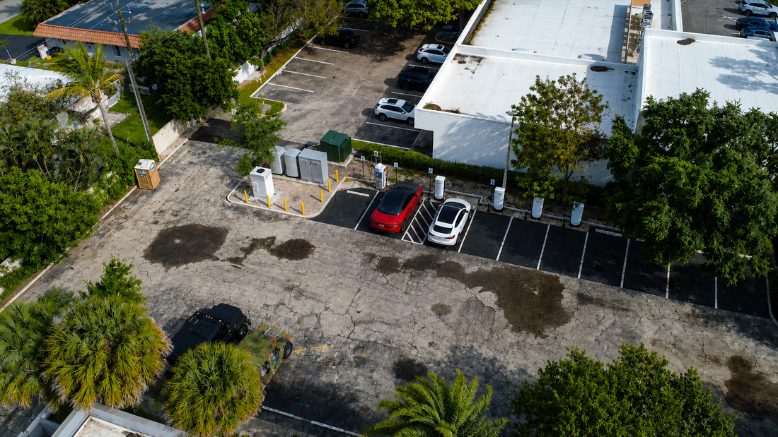 An aerial view of red and white cars at charging pedestals.