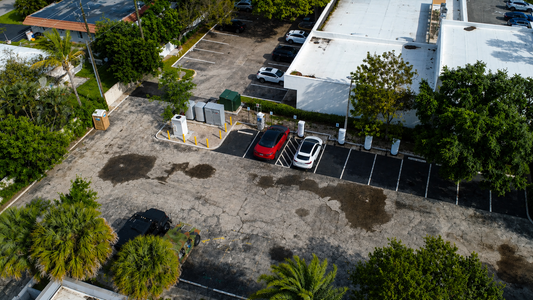 An aerial view of red and white cars at charging pedestals.
