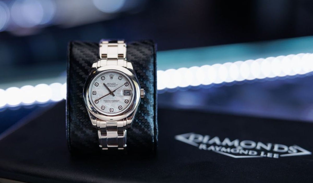 A Rolex Datejust on a showroom display cushion.