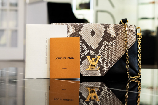 A Louis Vuitton flap handbag with a patterned exterior, chain strap and accompanying documents.
