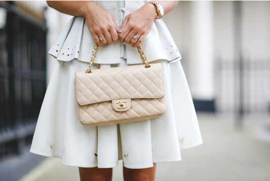 A cream quilted Chanel flap handbag with a chain strap.
