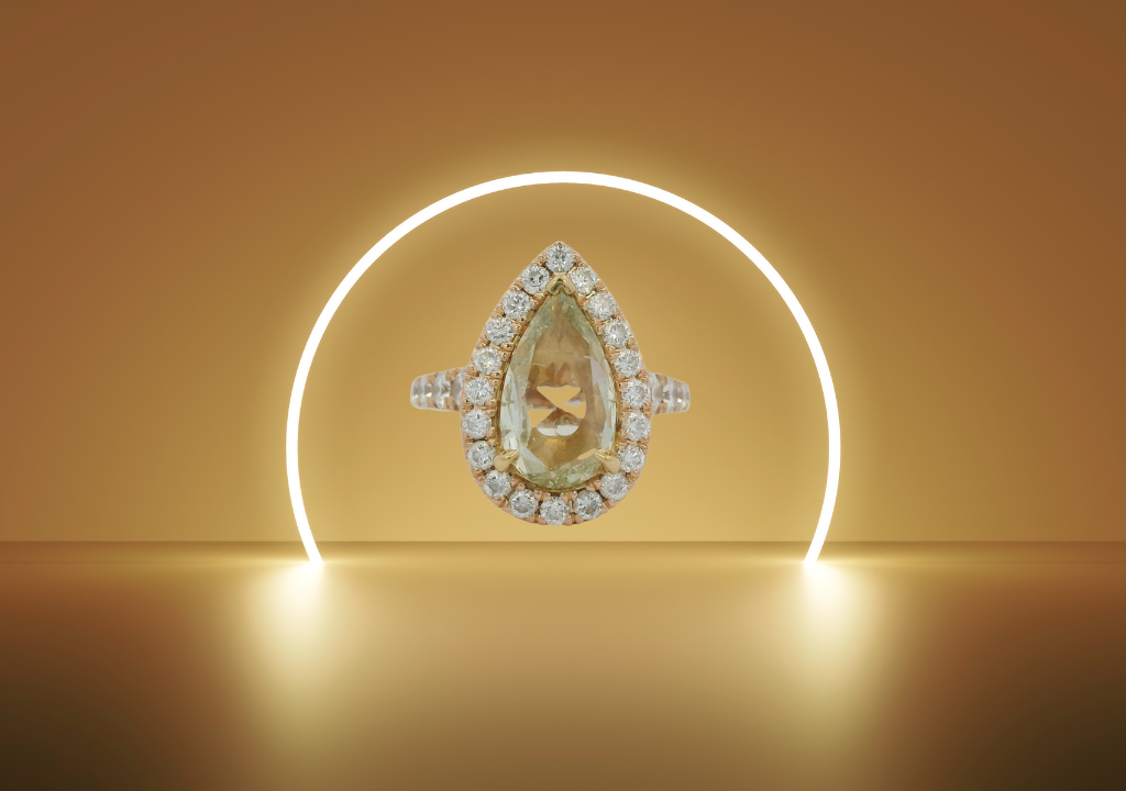 Henri Daussi style pear-shaped diamond wedding ring with halo setting, showcased on a warm golden background, symbolizing luxury and love.&nbsp;