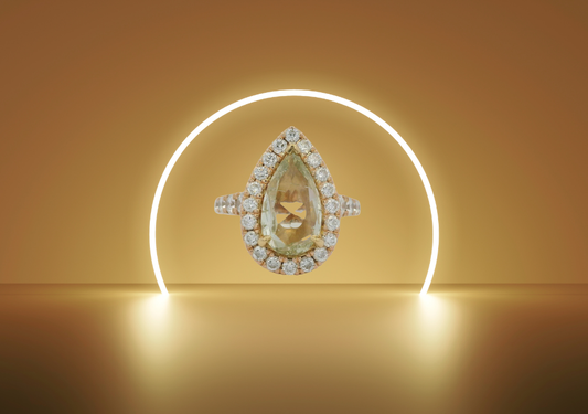 Henri Daussi style pear-shaped diamond wedding ring with halo setting, showcased on a warm golden background, symbolizing luxury and love.&nbsp;