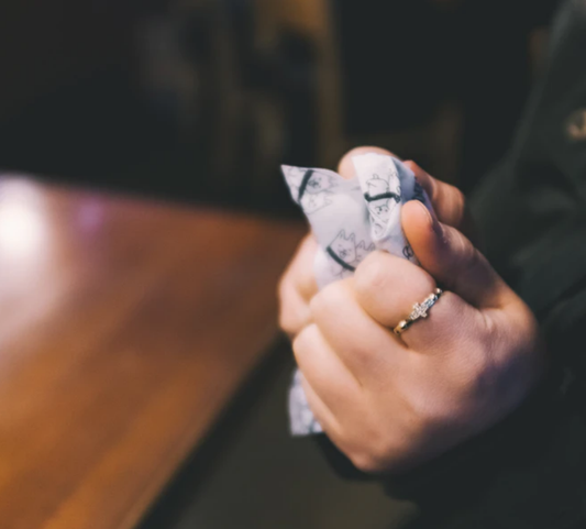 Hands holding a cleaning cloth while wearing a small stone ring