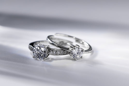 Two rings with round center stones and contrasting band designs.