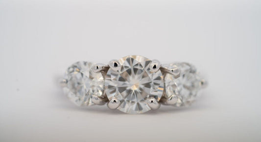 Three stone ring with round clear center and side stones.