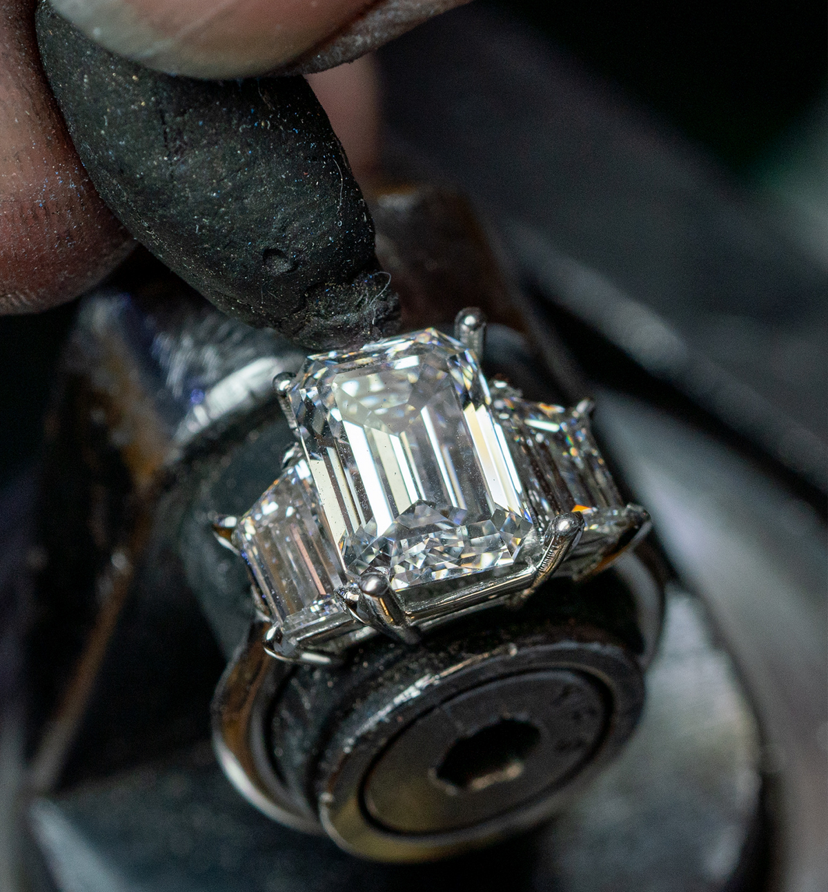 Close view of a rectangular stone ring held in a work holder