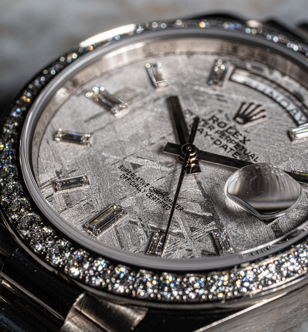 Close view of a Rolex dial with stone hour markers and a stone set bezel