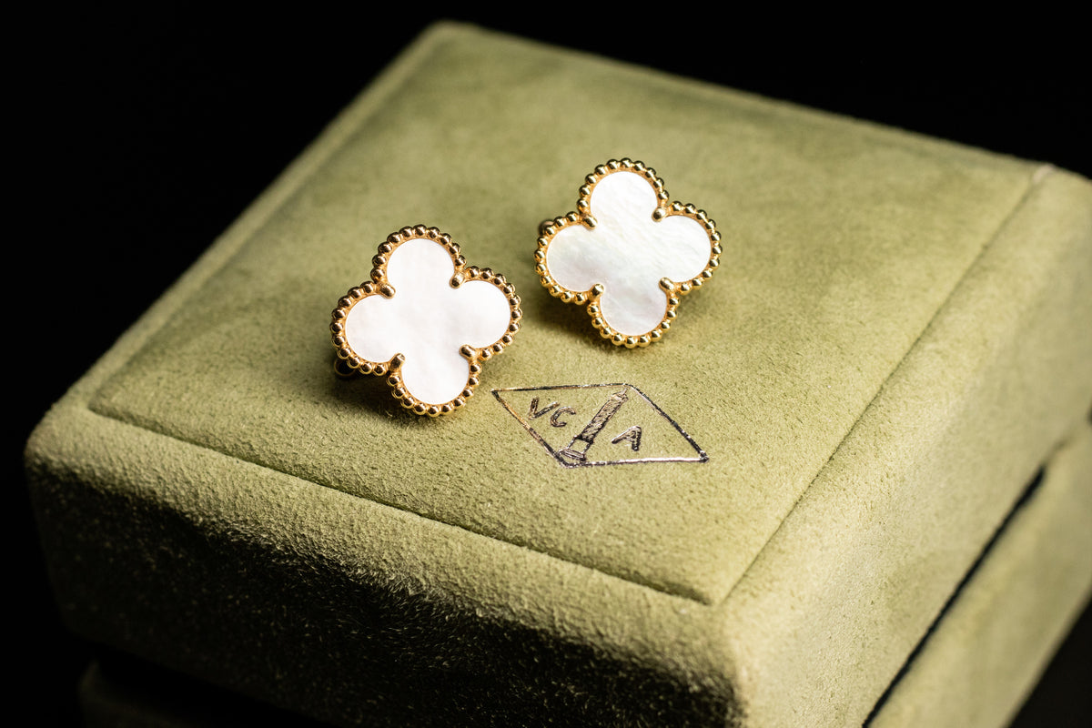 Van Cleef & Arpels motif earrings on a green presentation box