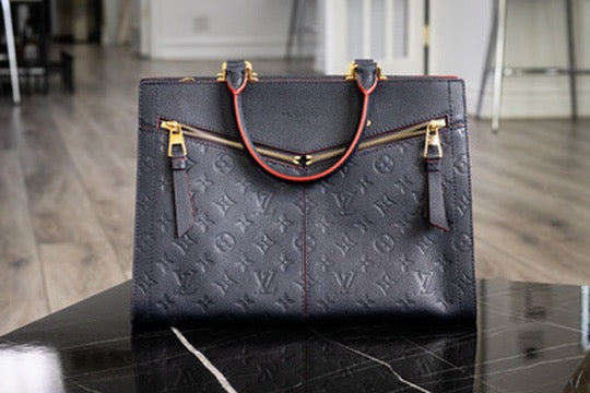 Dark Louis Vuitton monogram tote with red edged handles and gold tone zippers