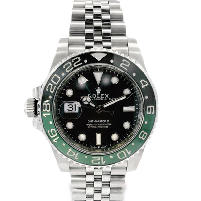 Rolex watch with black face and green bezel on a white background