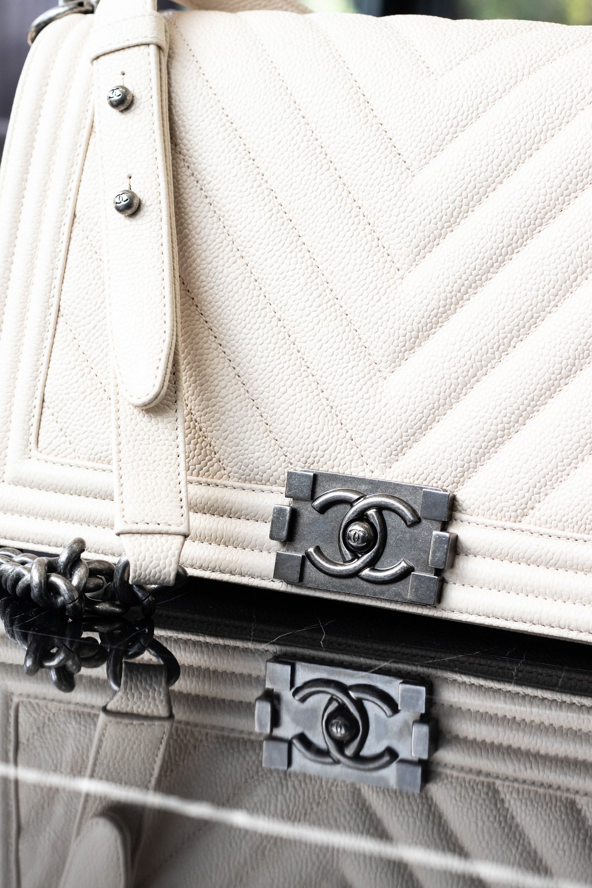 Cream Chanel handbag with chevron stitching and a dark metal clasp