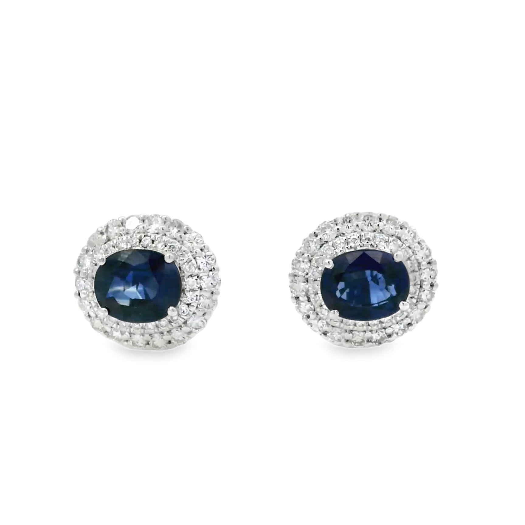 Pair of earrings with blue gemstones and silver surrounds on a white background