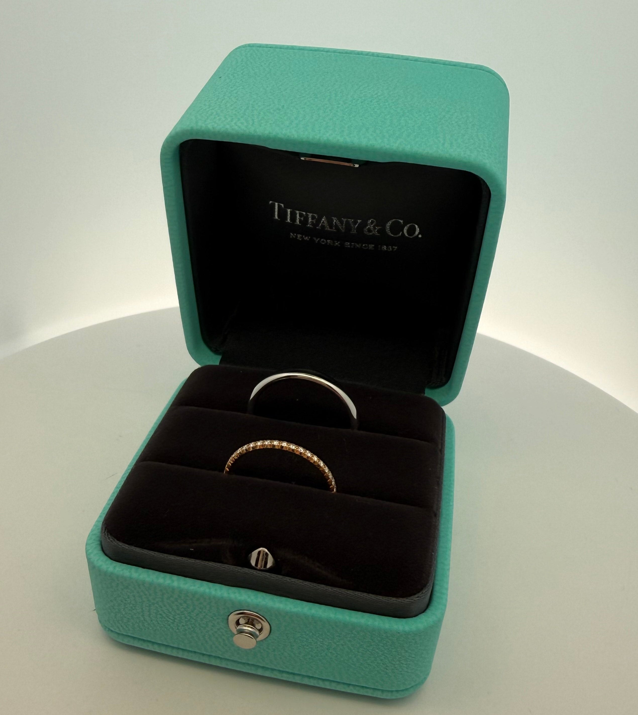 Tiffany & Co. jewelry box with two rings on a white background