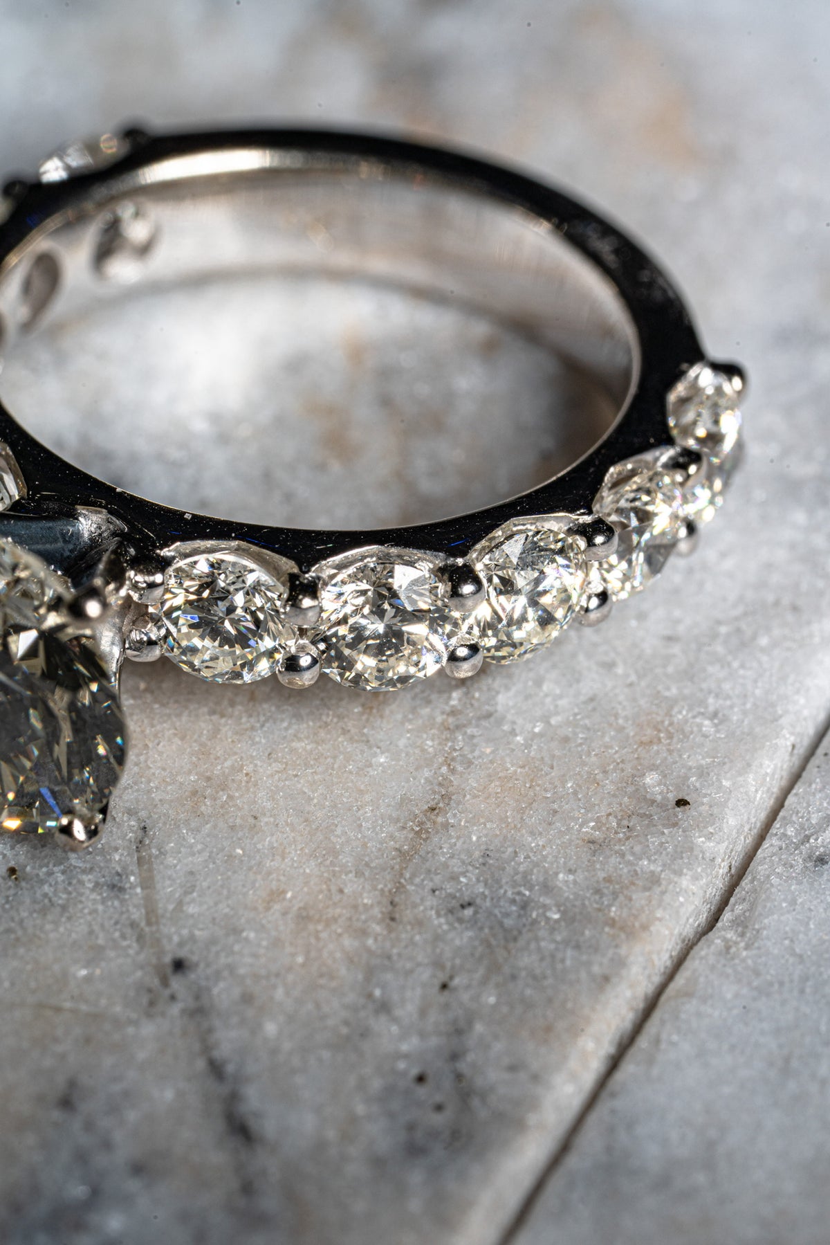 Stone-set ring resting on a light-colored cushion