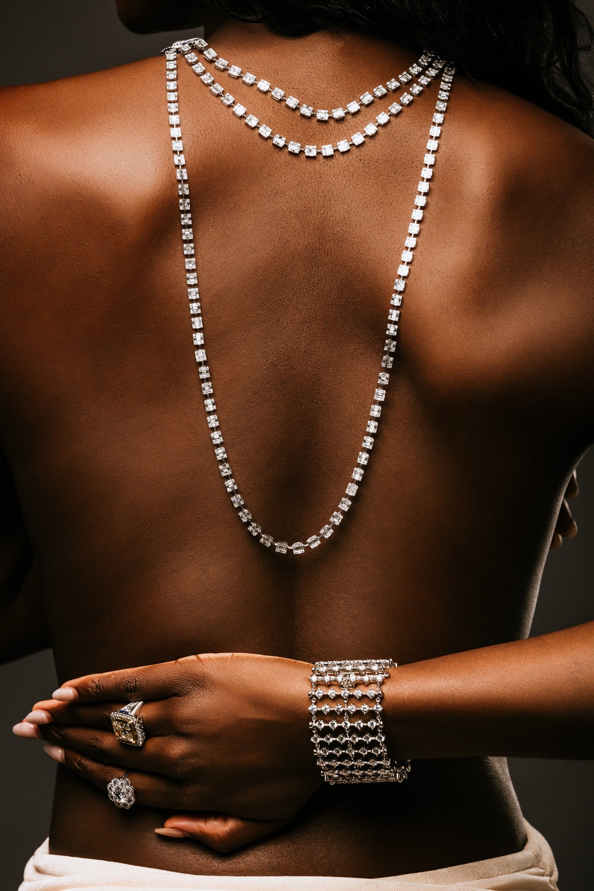 Layered necklaces, a wide bracelet and statement rings