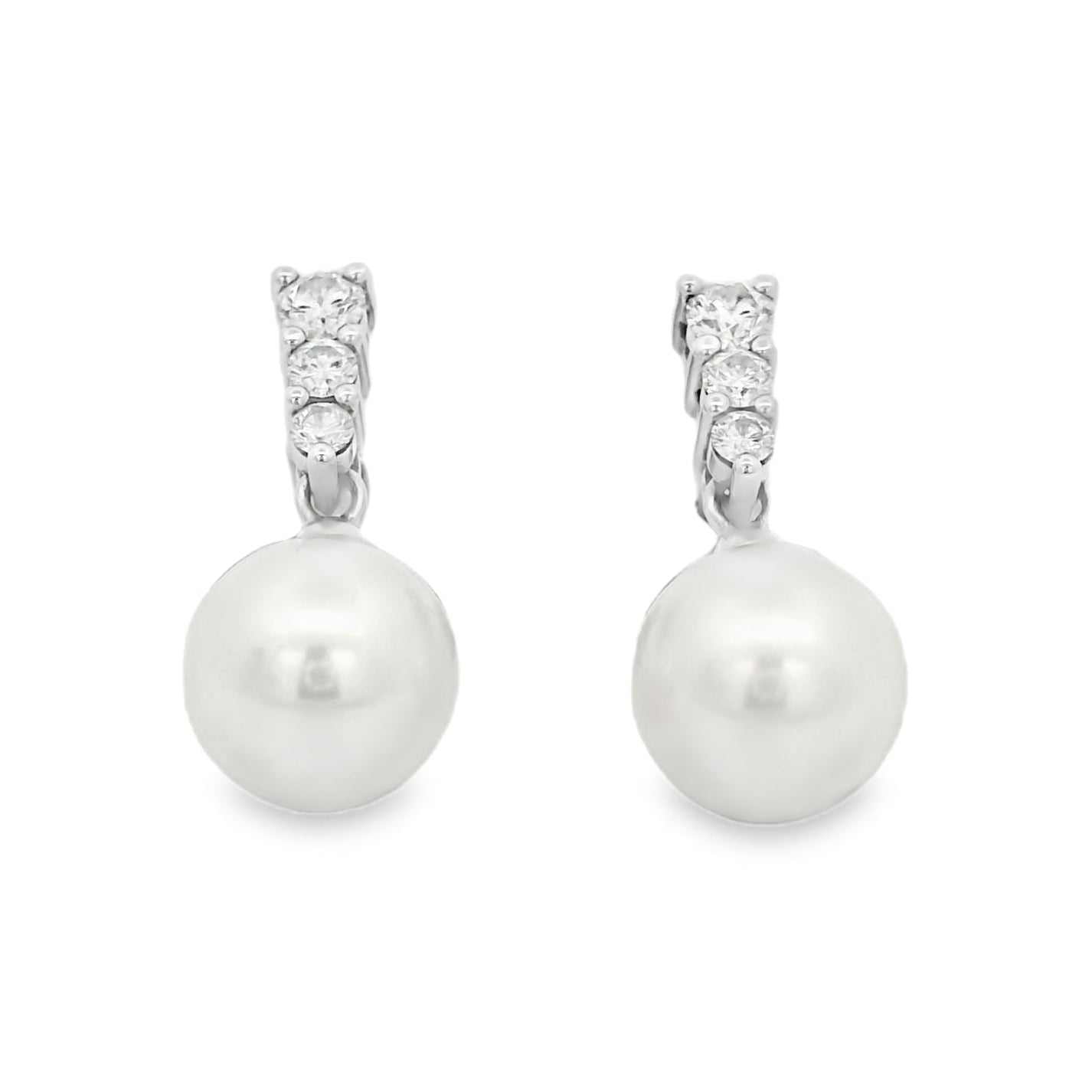Pearl earrings with silver and clear gemstone accents on a white background