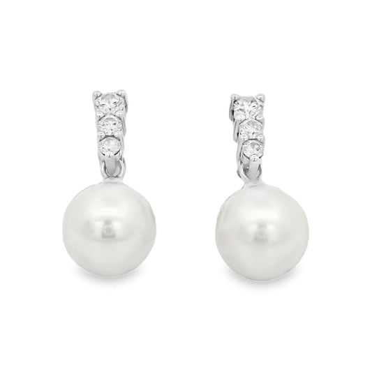 Pearl earrings with silver and clear gemstone accents on a white background