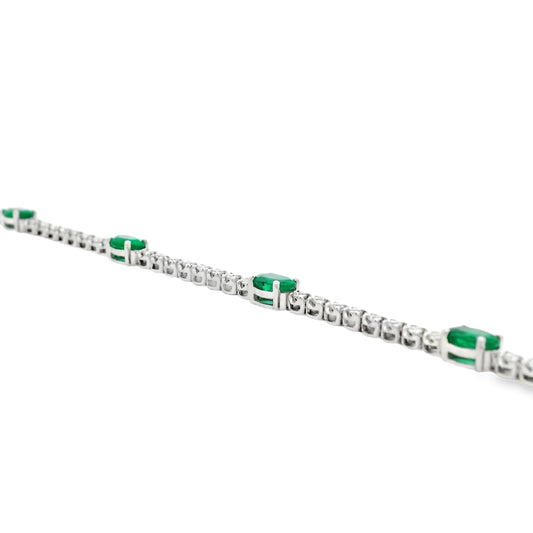 14k White Gold 5.88ctw Oval Emerald and Round Brilliant Diamond Tennis Bracelet — left three-quarter angle