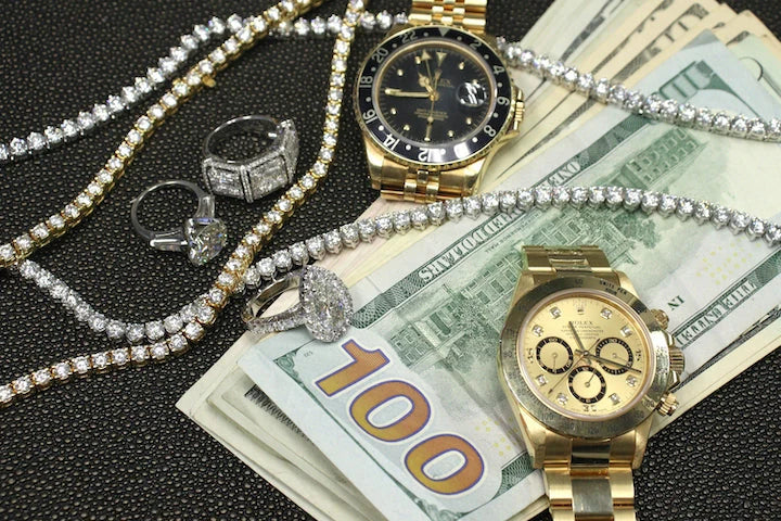 Gold tone watches, stone set jewelry and currency arranged together