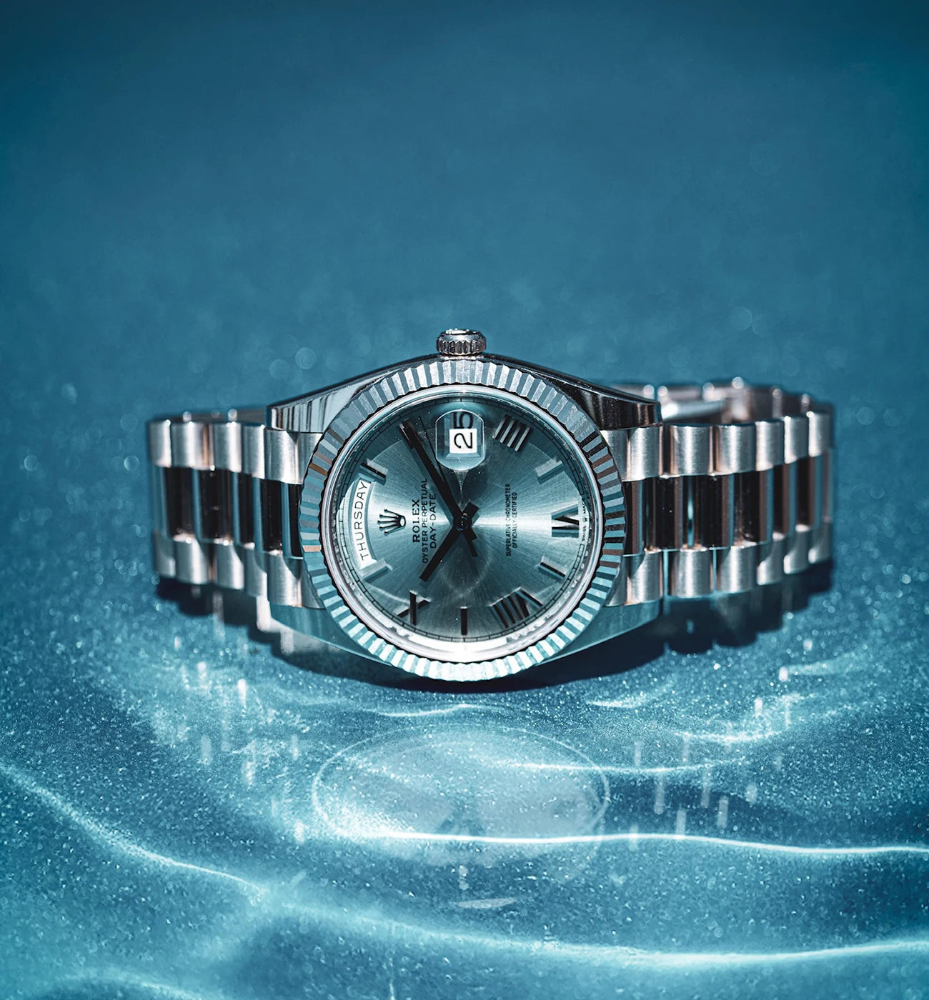 Wristwatch with Roman numerals and a metal bracelet on a blue background