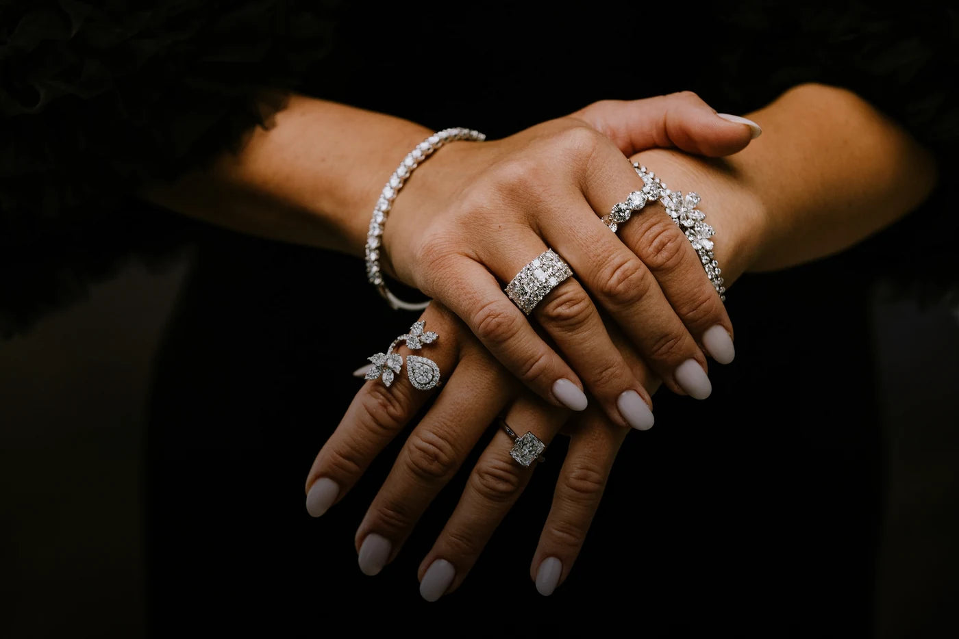 Hands wearing statement rings and a bracelet
