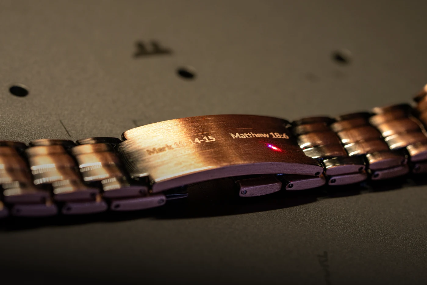 Close view of an engraved metal watch bracelet clasp