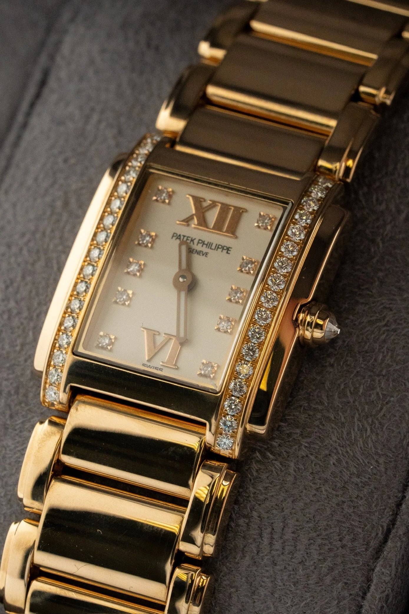 Rectangular watch with a gold tone bracelet and stone set case