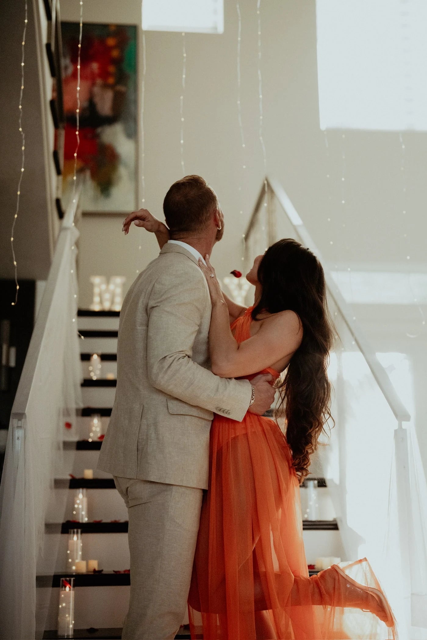 Couple standing together beside a decorated staircase