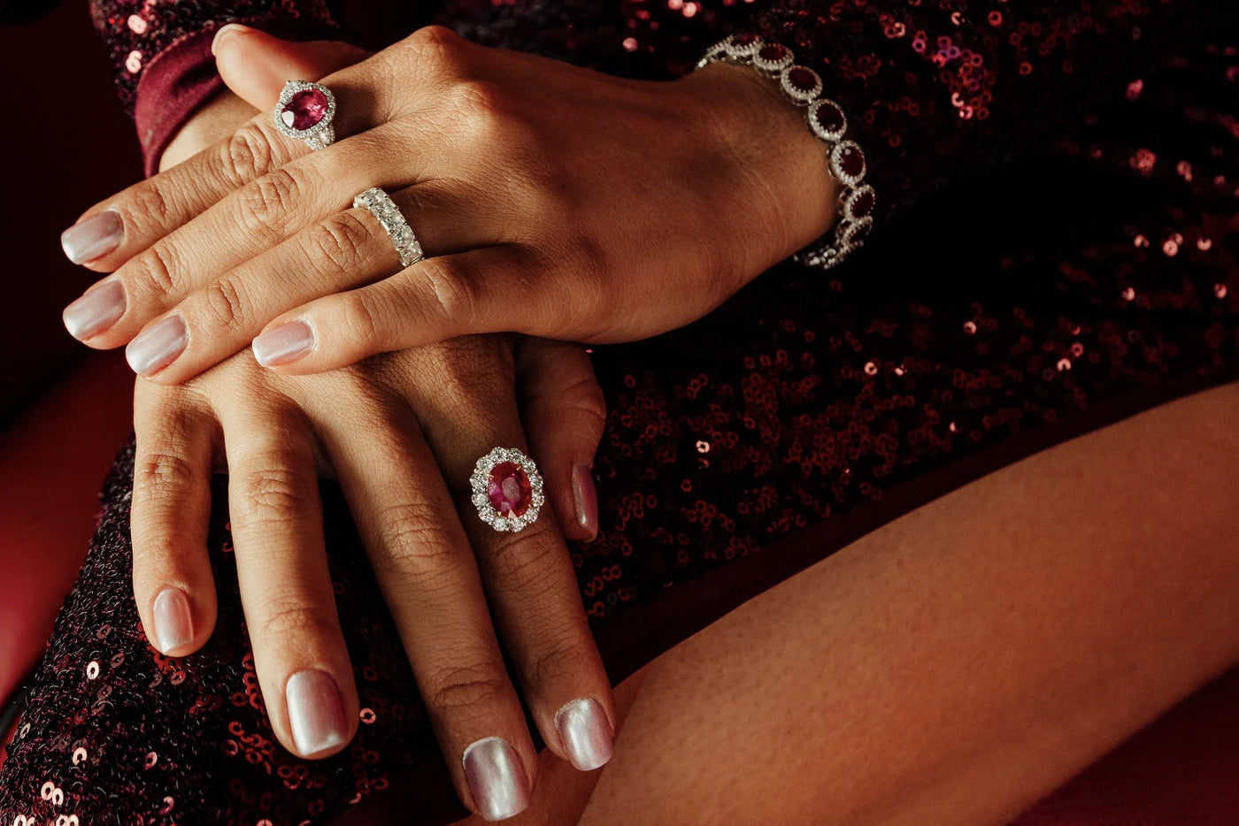 Red gemstone rings and bracelets worn with a burgundy dress