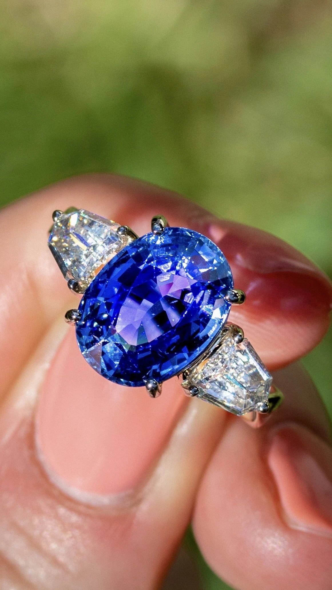 Oval blue center stone with light-colored side stones in a ring